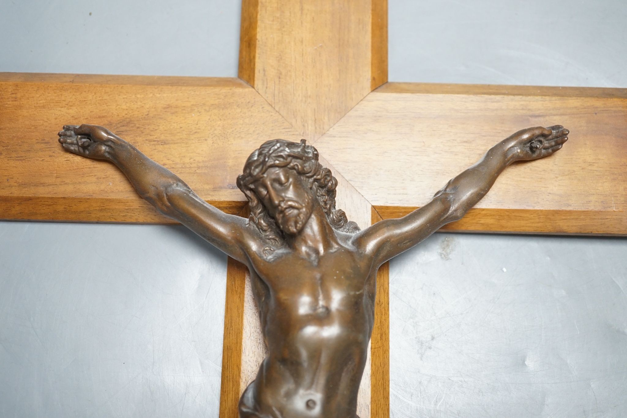 A bronze crucifix, mounted on a wooden cross, Height of cross, 60.5 cms.
